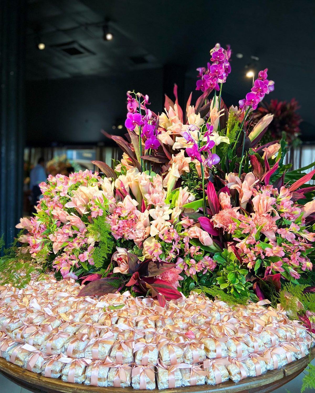 Arranjo de orquídeas sobre mesa de lembrancinhas