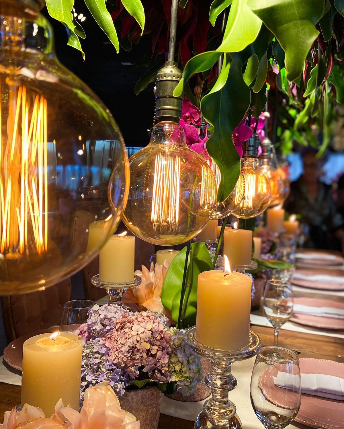 Mesa posta com velas e lâmpadas de filamento